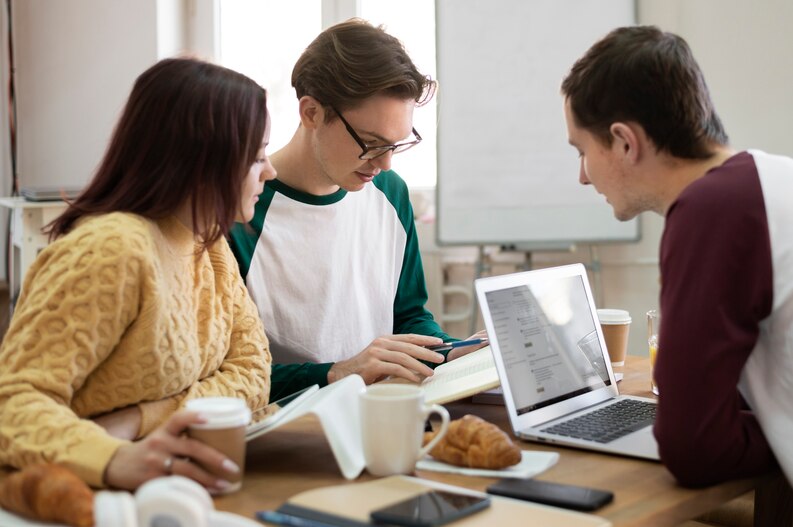 An intern analyzing reports and discussing findings in a business team meeting.