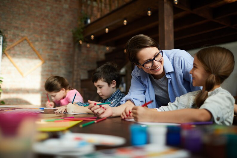 Early childhood educator interacting with children during a classroom activity.