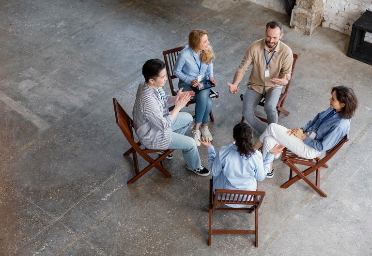 Community service professionals interacting with community members in a supportive setting.