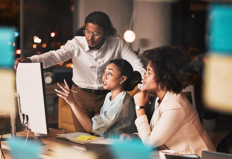 A diverse group of young professionals working together in a modern office environment