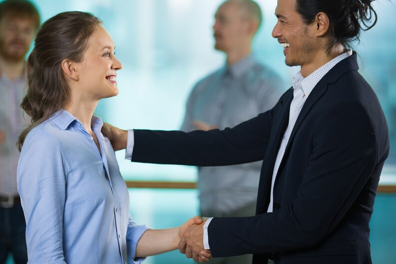 A close-up of two professionals shaking hands at a business event