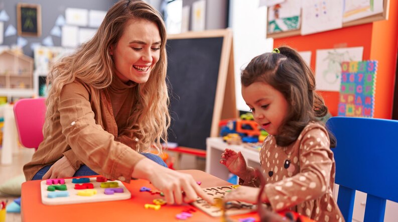 A teacher engaging with young children in an early childhood education setting.