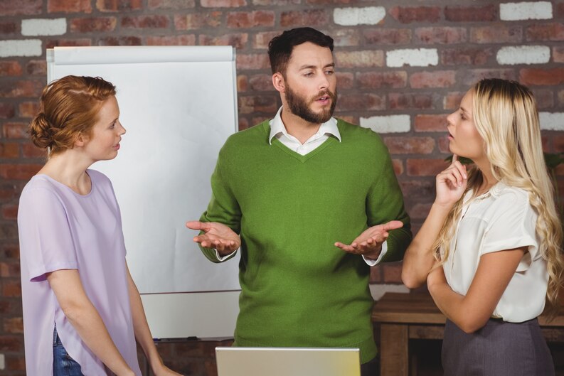 A professional mentor guiding an intern, offering constructive feedback on their work.