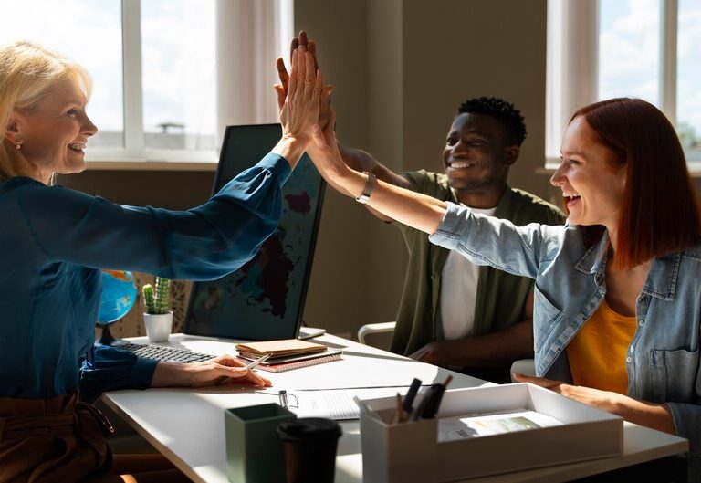 A diverse team of professionals celebrating a career milestone in a modern office.