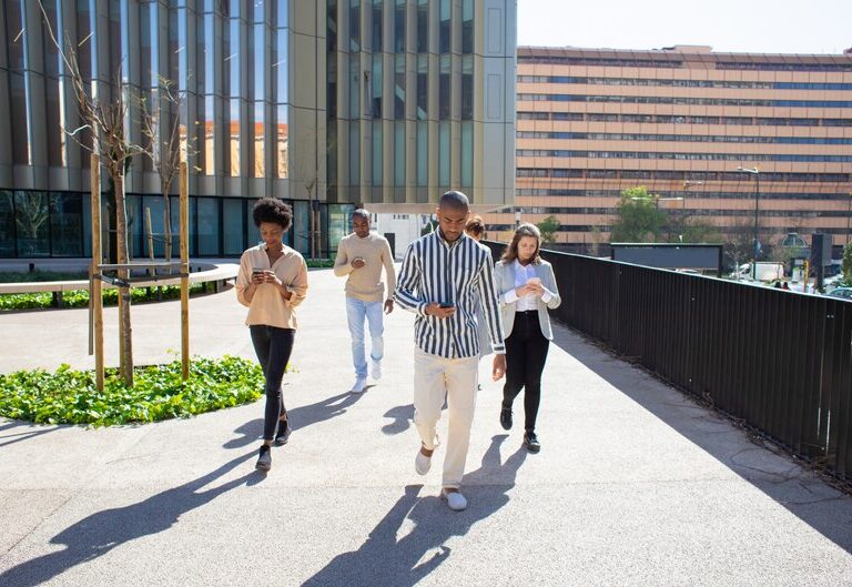 Diverse group of Australian students walking toward a modern office building