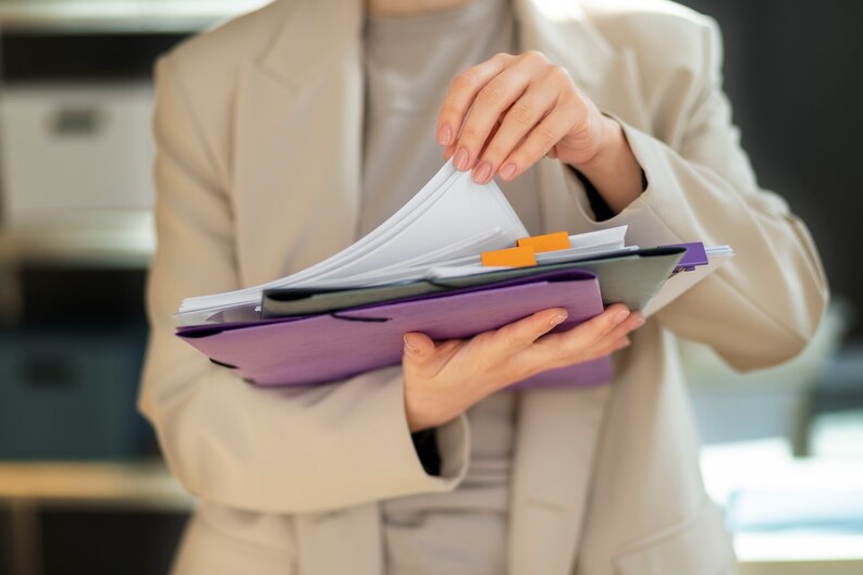 Person sorting important placement documents into folders.