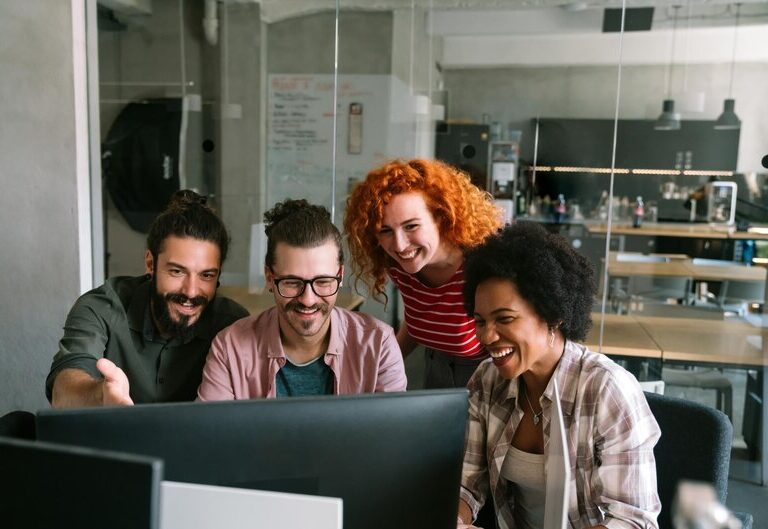 Group of young professionals collaborating and smiling in a modern workspace