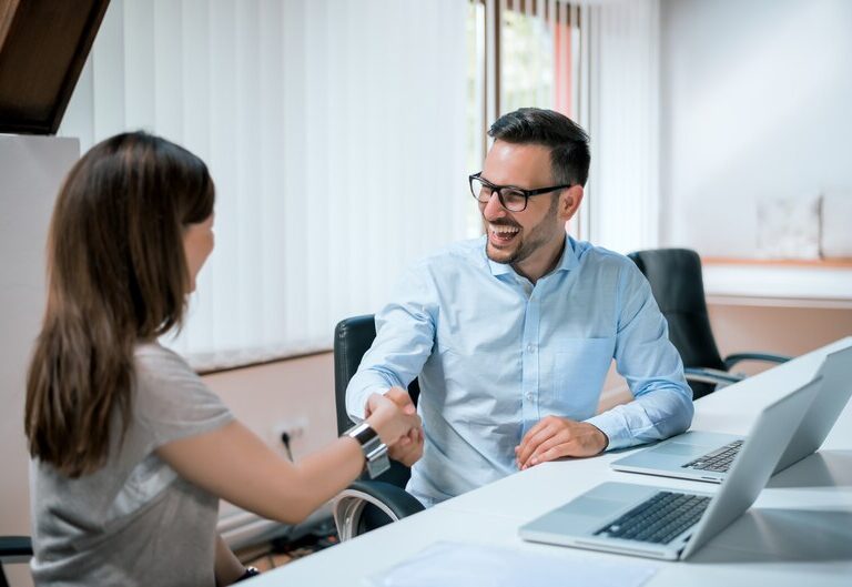 Intern shaking hands with manager in an office setting
