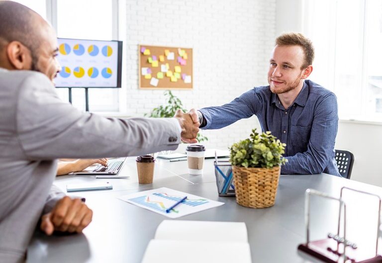 Intern shaking hands with manager in an office setting